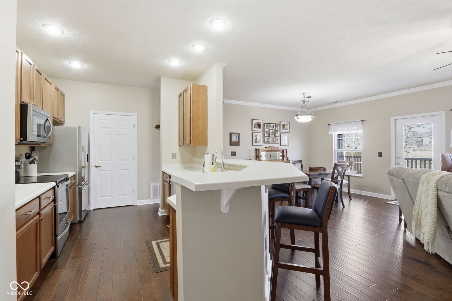 Bright open kitchen with island and hardwood floors.
