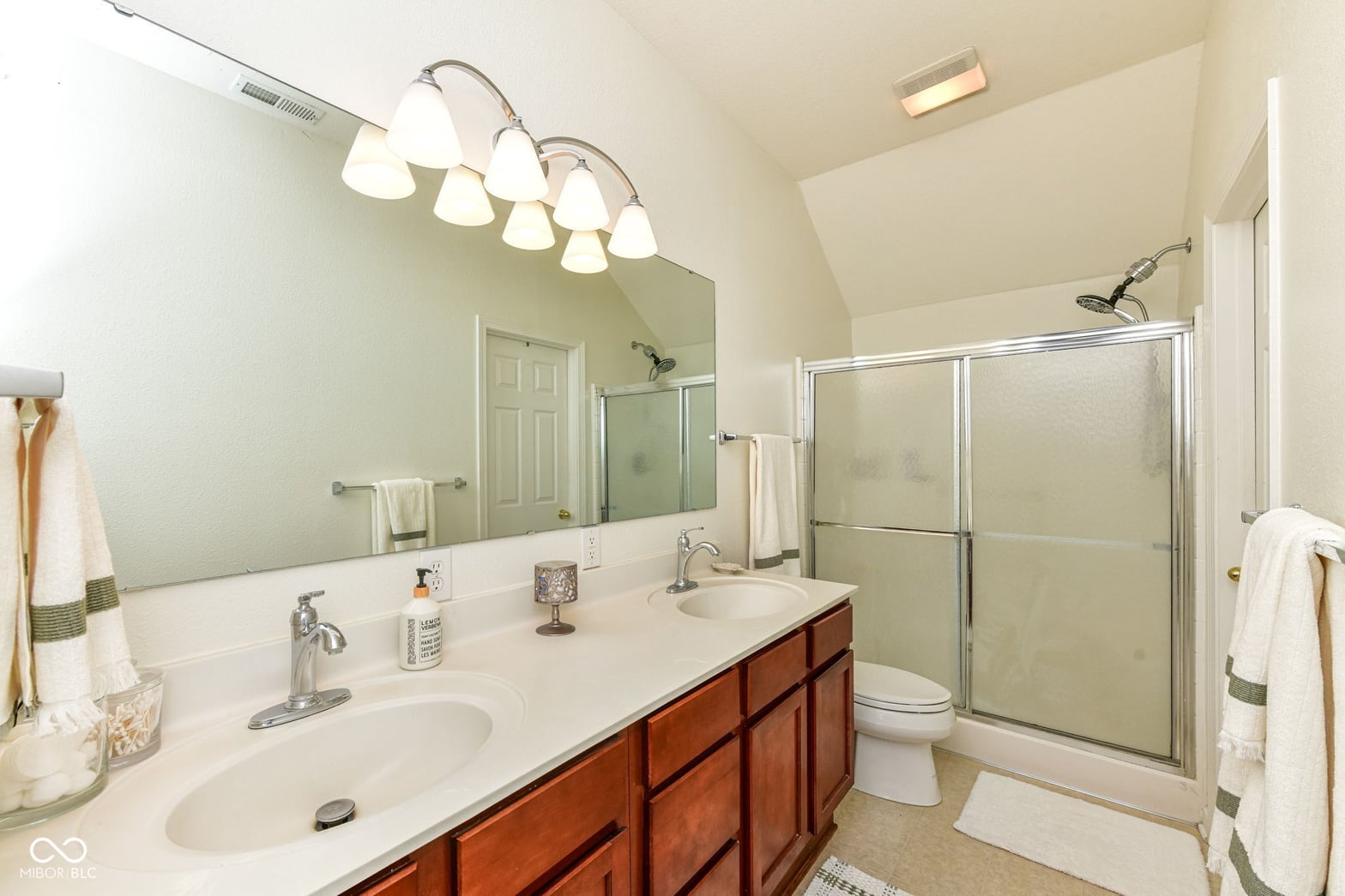 Spacious primary bath with dual vanity and walk-in shower.