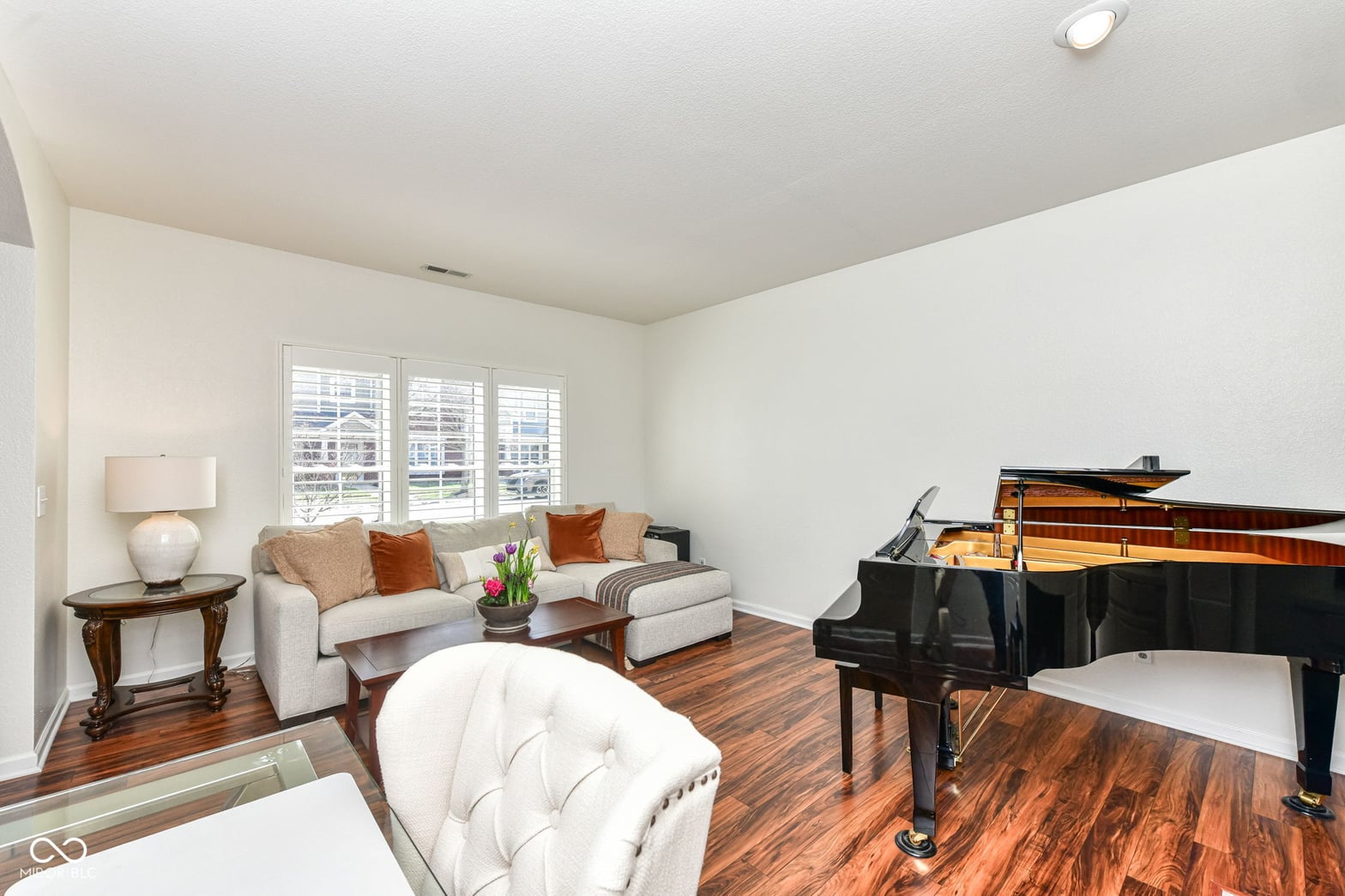 Elegant living space with grand piano and hardwood floors.