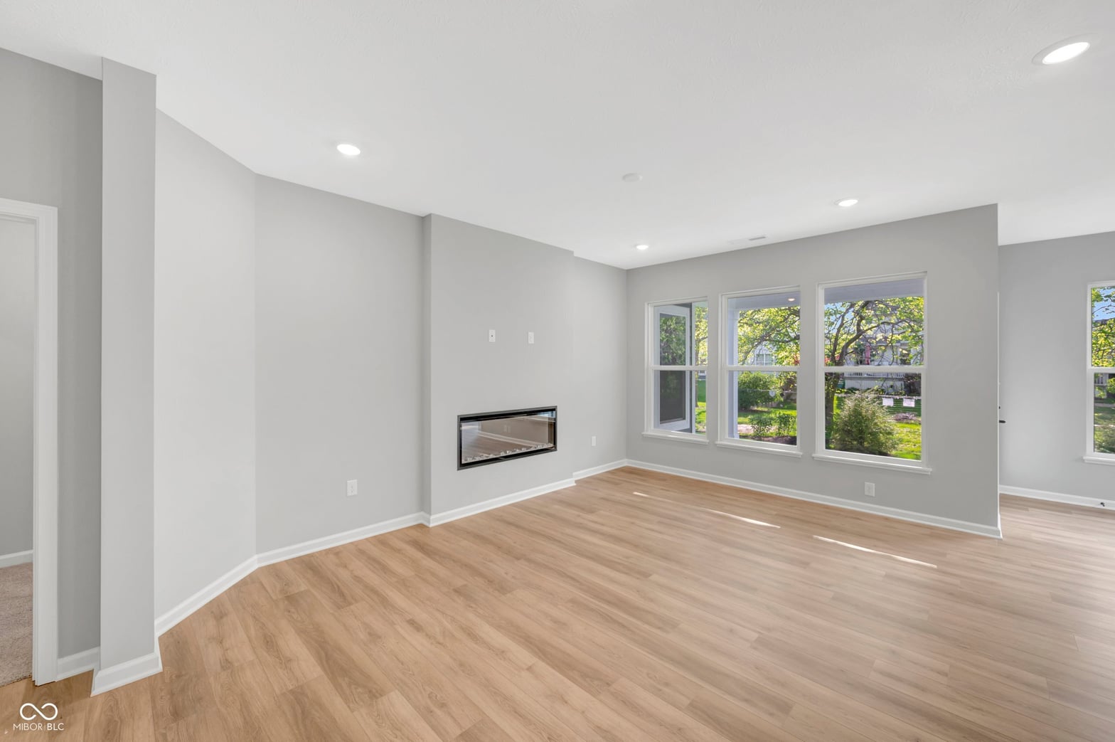 Bright family room with fireplace and abundant natural light.