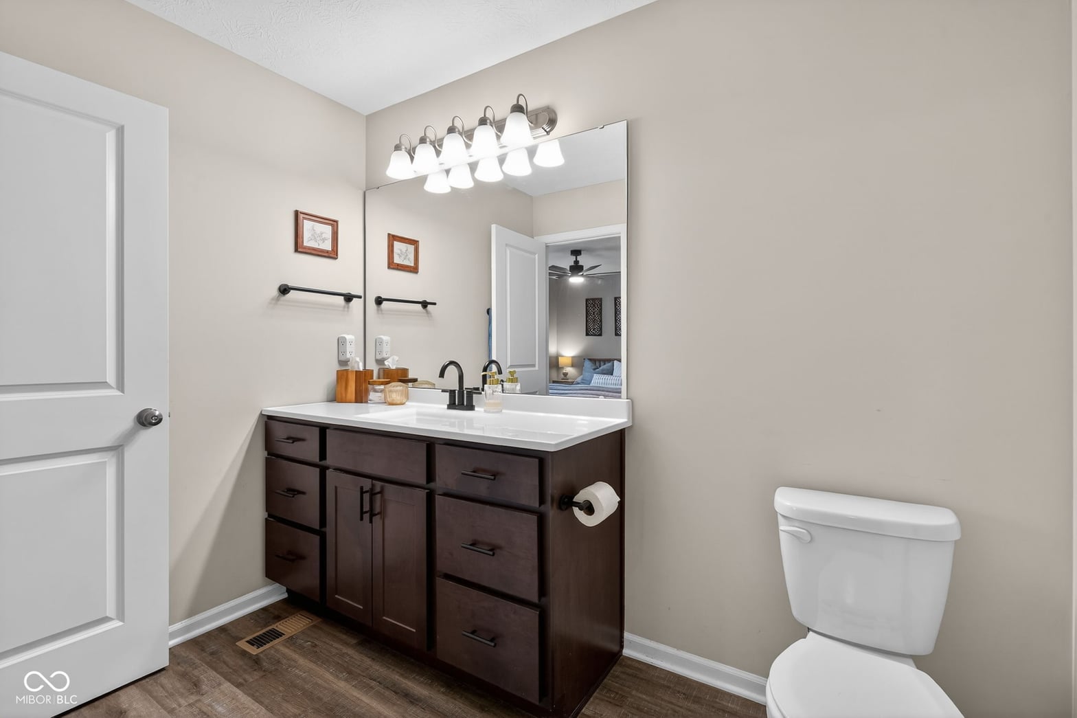 Updated primary bathroom with dark wood vanity and modern fixtures.