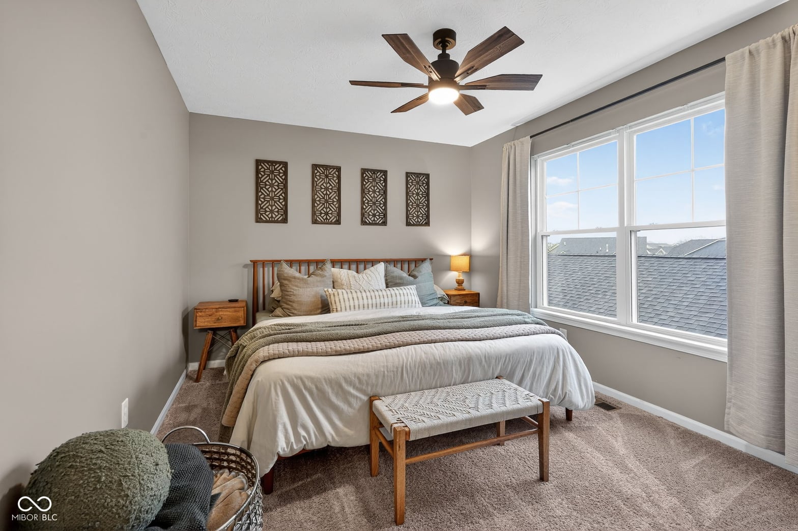 Bright primary bedroom with expansive windows and modern finishes.