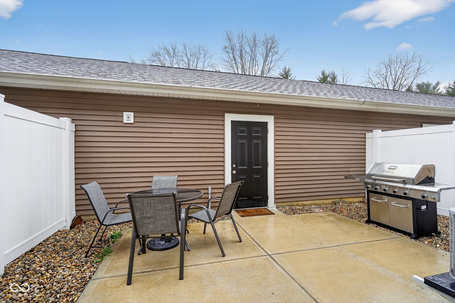 Modern outdoor living space with built-in grill and patio.
