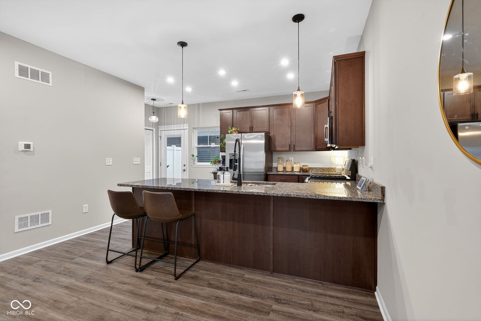Modern kitchen with granite island and premium stainless appliances.