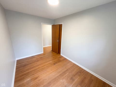 Bedroom at 10209 Broadway Street, Indianapolis, IN — Bright bedroom with updated hardwood floors and fresh paint.