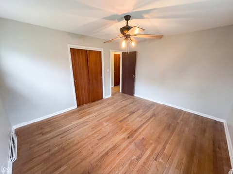 Bedroom at 10209 Broadway Street, Indianapolis, IN — Spacious bedroom with hardwood floors and ceiling fan.