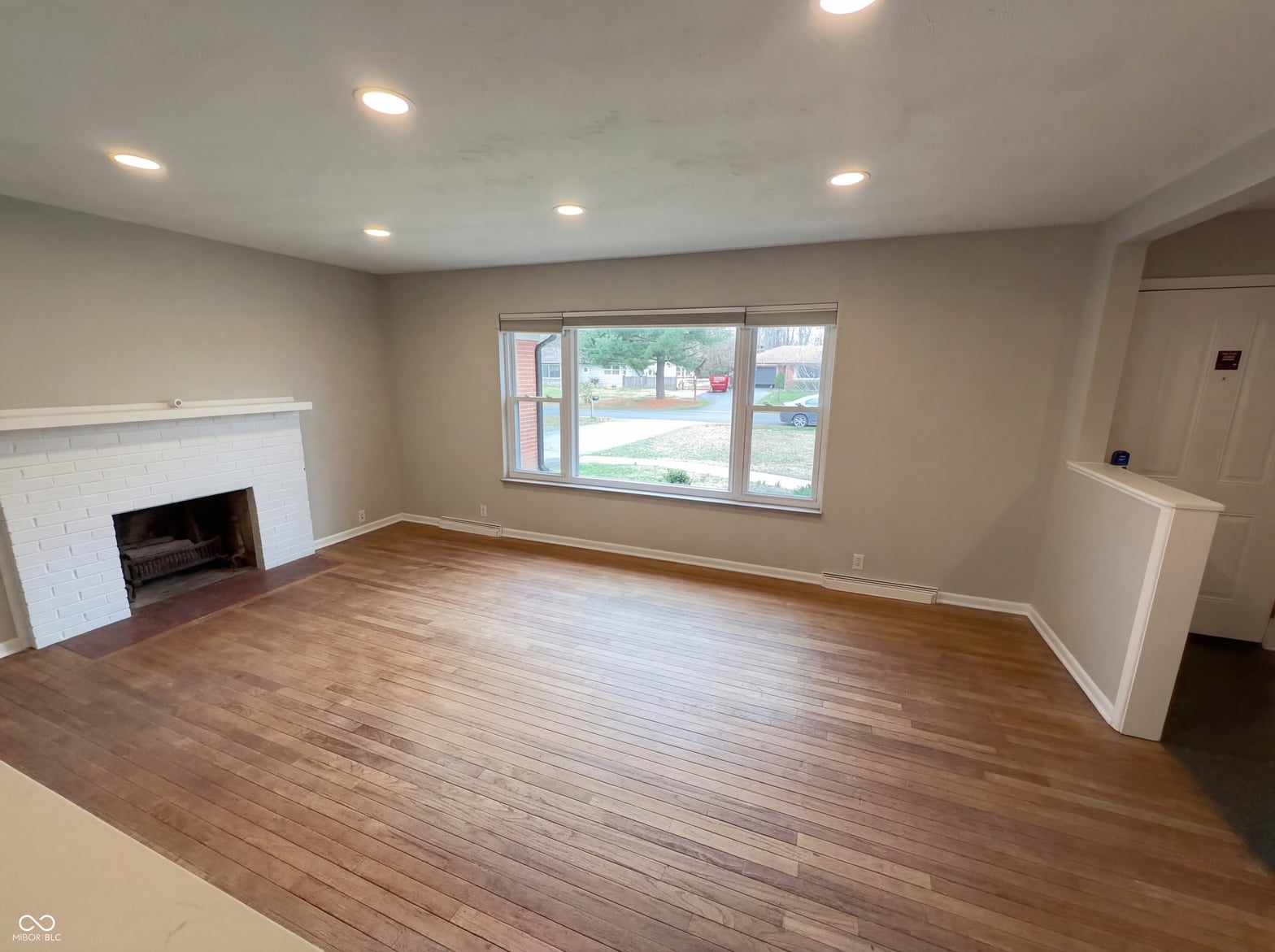 Living room at 10209 Broadway Street, Indianapolis, IN — Bright living room with fireplace and hardwood flooring.