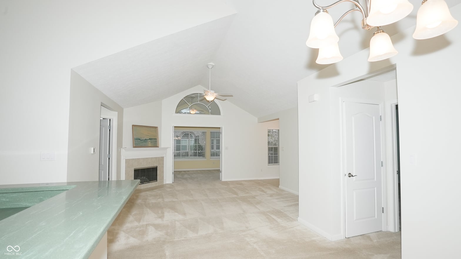 Bright family room with vaulted ceilings and fireplace.