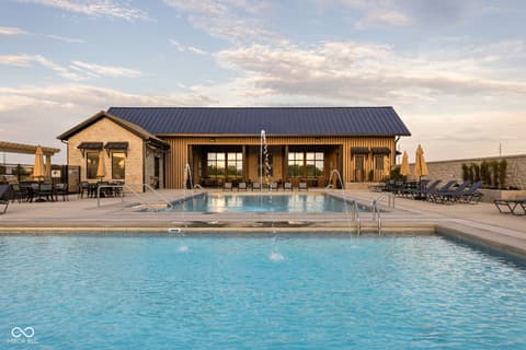 Outdoor living area at 17448 Carrier Drive, Westfield, IN — Stunning resort-style pool and spa with modern clubhouse.