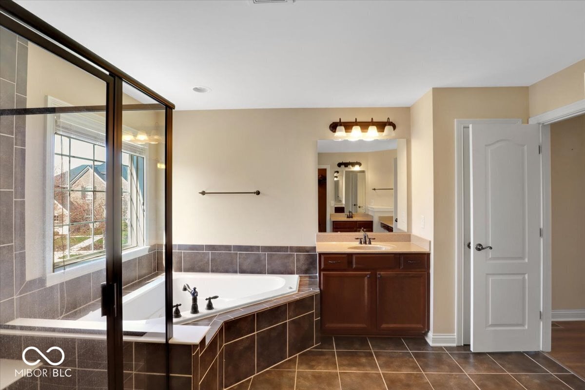 Spacious primary bath with dual vanity and soaking tub.