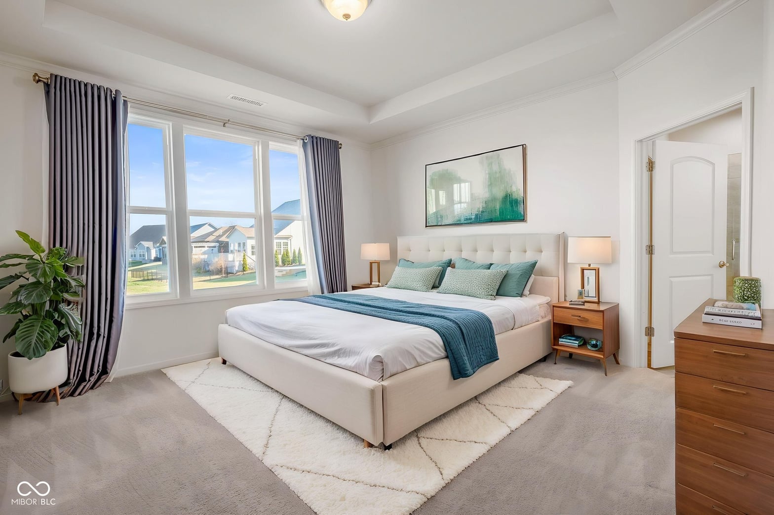 Bright primary suite with expansive bay windows and views.