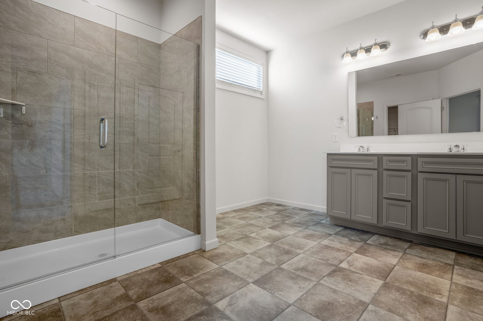 Spacious primary bath with frameless shower and dual vanity.