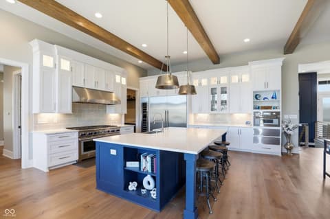 Kitchen at 17112 Sanders Farm Circle, Westfield, IN — Stunning updated kitchen with blue island and exposed beams.