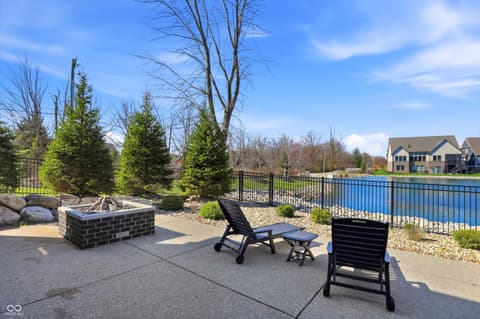 Outdoor living area at 17112 Sanders Farm Circle, Westfield, IN — Waterfront patio with fire pit and modern amenities.