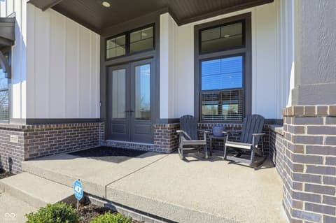 Front exterior at 17112 Sanders Farm Circle, Westfield, IN — Modern front porch with brick and covered seating area.