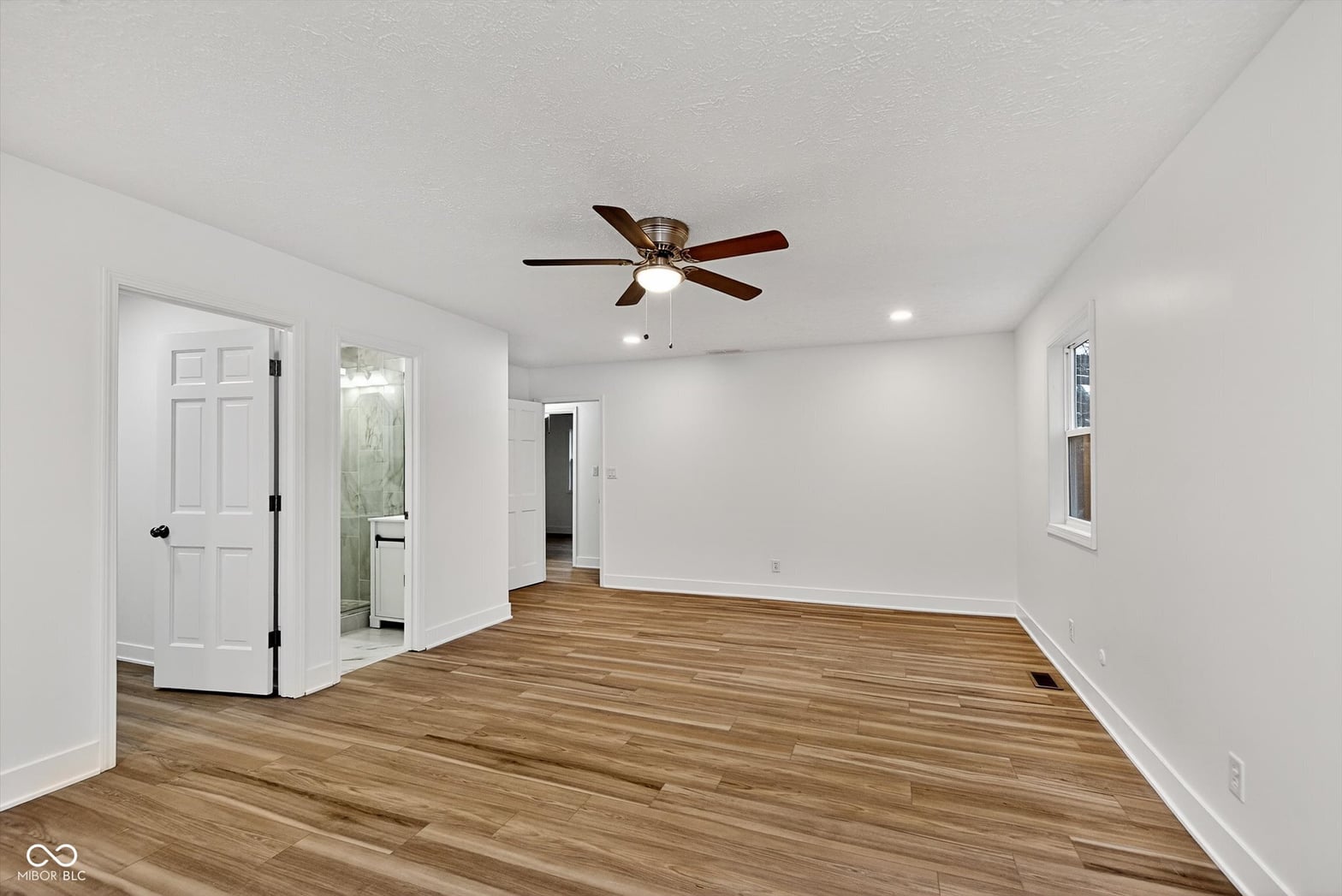 Spacious primary bedroom with hardwood floors and ensuite.