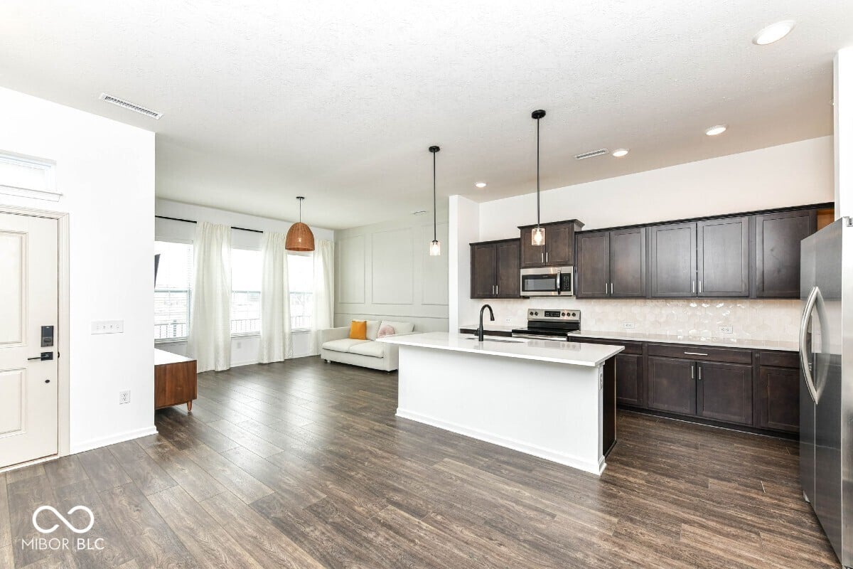 Modern kitchen with dark cabinetry and white island.
