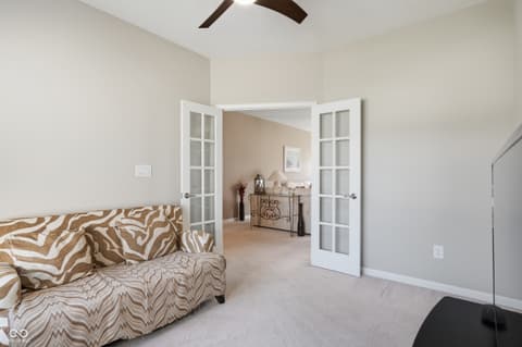 Primary bedroom at 9704 Brook Wood Drive, McCordsville, IN — Spacious primary suite with sitting area and double doors.