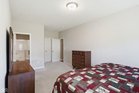 Primary bedroom at 9704 Brook Wood Drive, McCordsville, IN — Spacious primary bedroom with ensuite bathroom access.