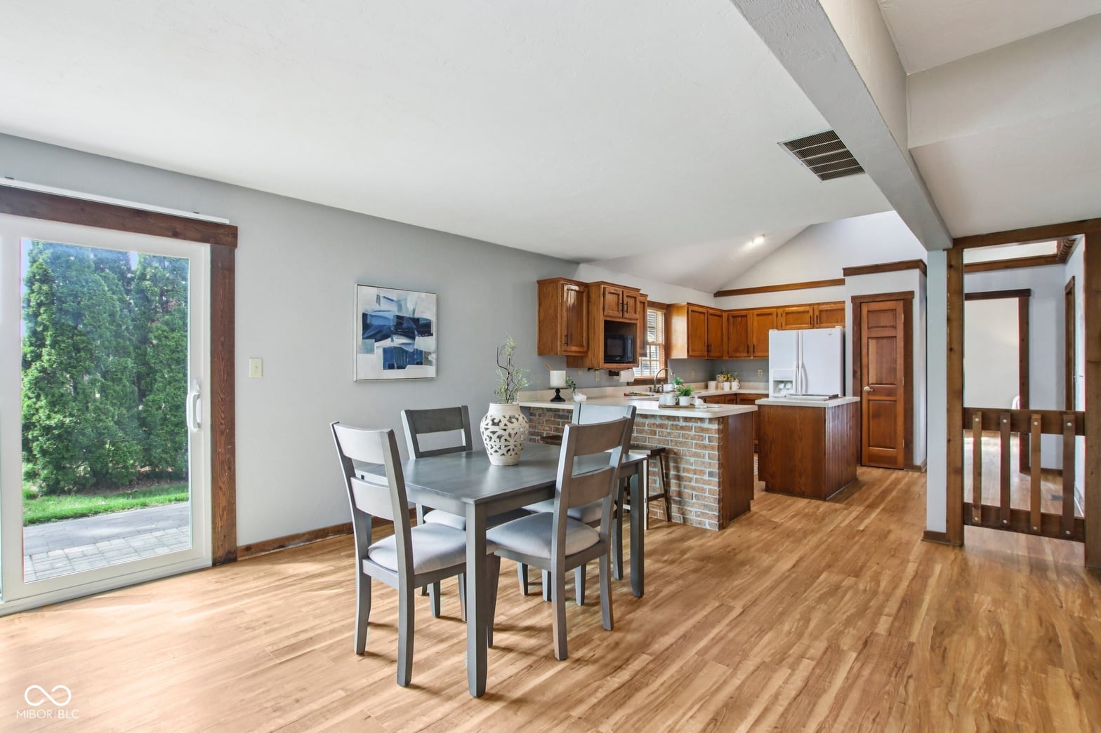 Open-concept dining with vaulted ceilings and outdoor access.