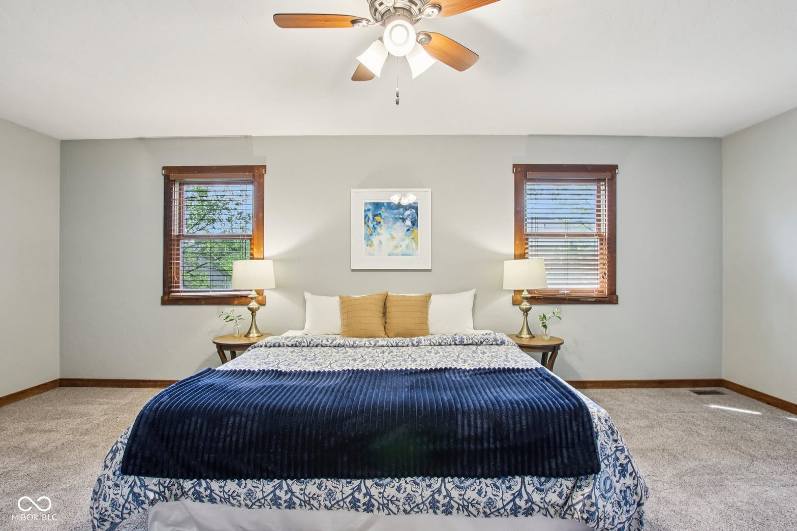 Bright primary bedroom with dual windows and quality finishes.