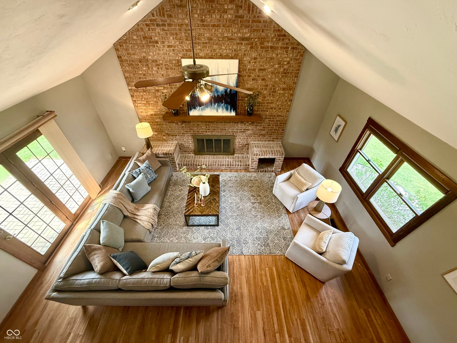 Bright vaulted family room with exposed brick fireplace.