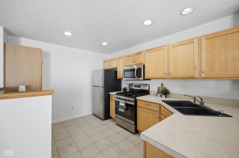 Kitchen at 12706 Brewton Street, Fishers, IN — Updated kitchen with oak cabinets and stainless appliances.
