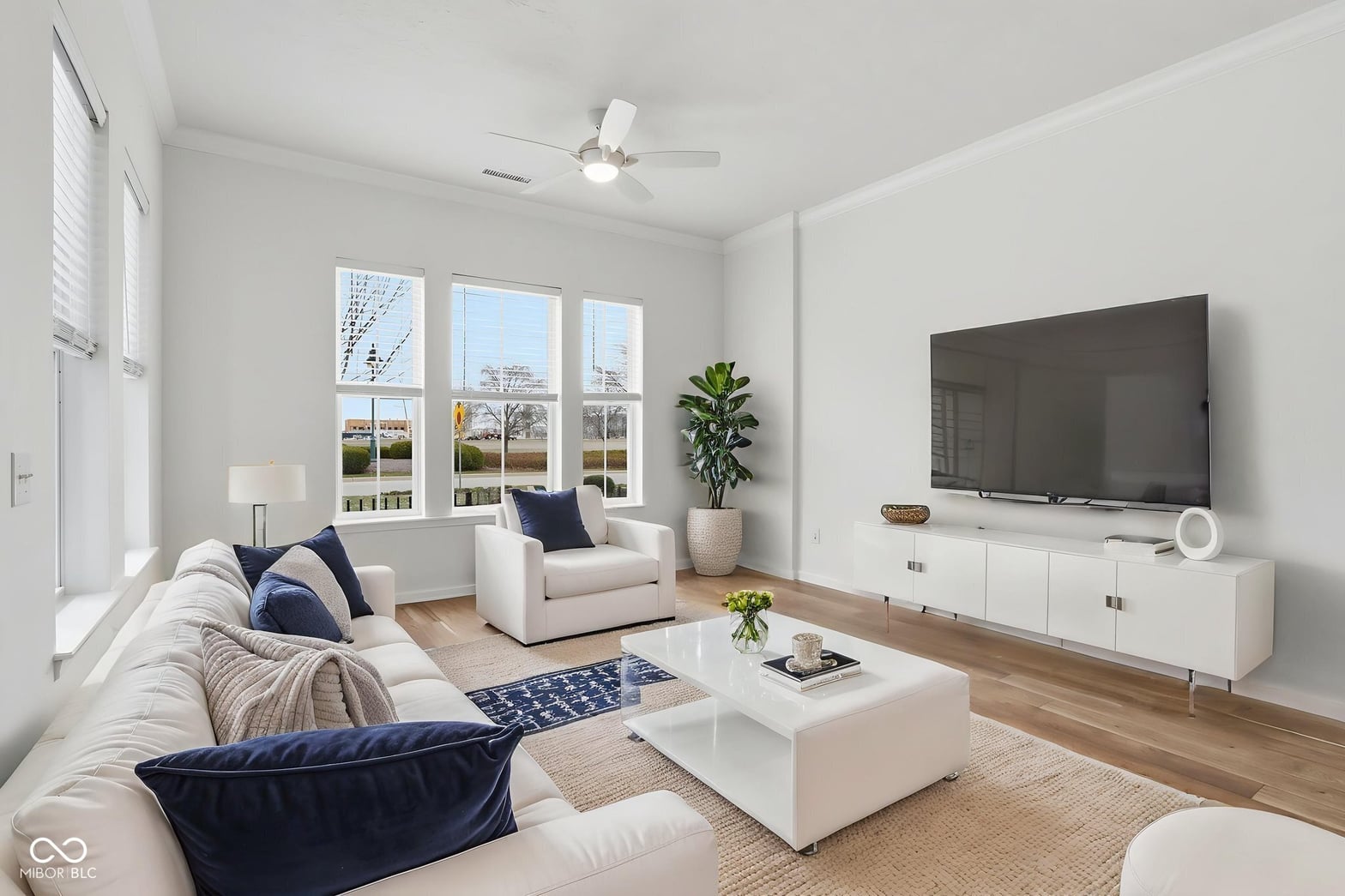 Bright contemporary living room with expansive windows and hardwood floors.