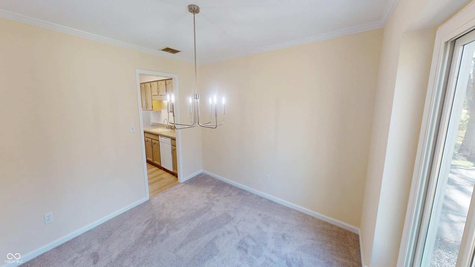 Bright dining room with glass doors and open kitchen layout.