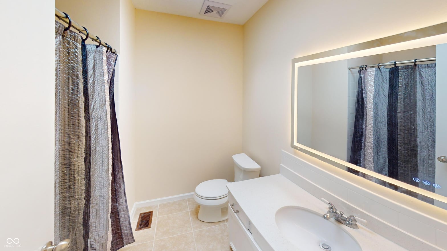 Modern bathroom with LED vanity mirror and clean finishes.