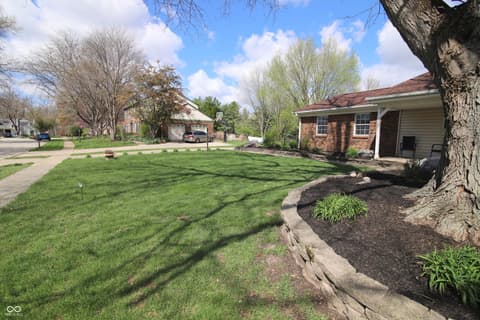 Front exterior at 104 Apple Tree Court, Fishers, IN — Charming brick home with mature trees and spacious yard.