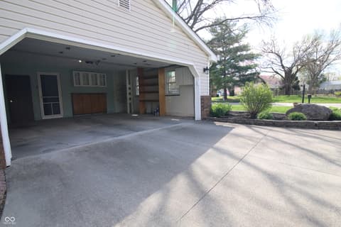 Front exterior at 104 Apple Tree Court, Fishers, IN — Spacious driveway with open garage and mature landscaping.