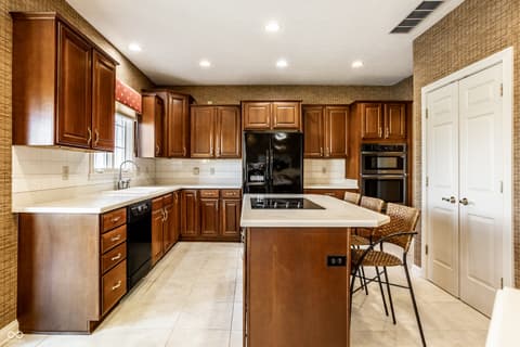 Kitchen at 2444 Laurel Lake Boulevard, Carmel, IN — Spacious kitchen with rich wood cabinetry and large island.