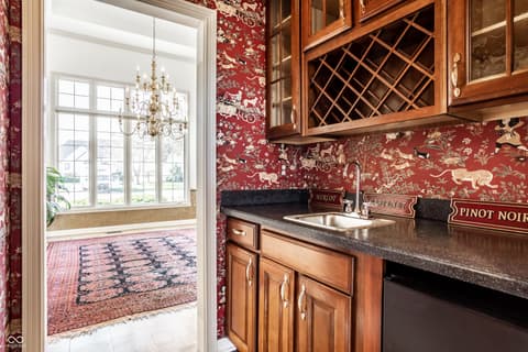 Kitchen at 2444 Laurel Lake Boulevard, Carmel, IN — Elegant wine bar kitchen with custom cabinetry and granite.