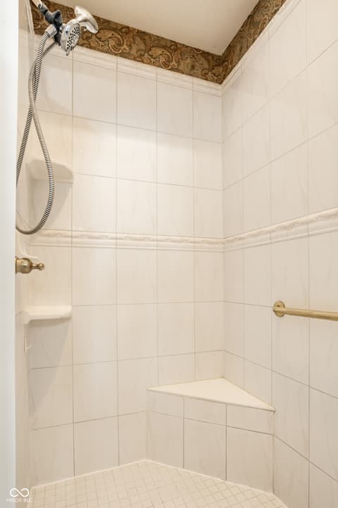Bathroom at 2444 Laurel Lake Boulevard, Carmel, IN — Classic tile shower with built-in shelving and grab bar.