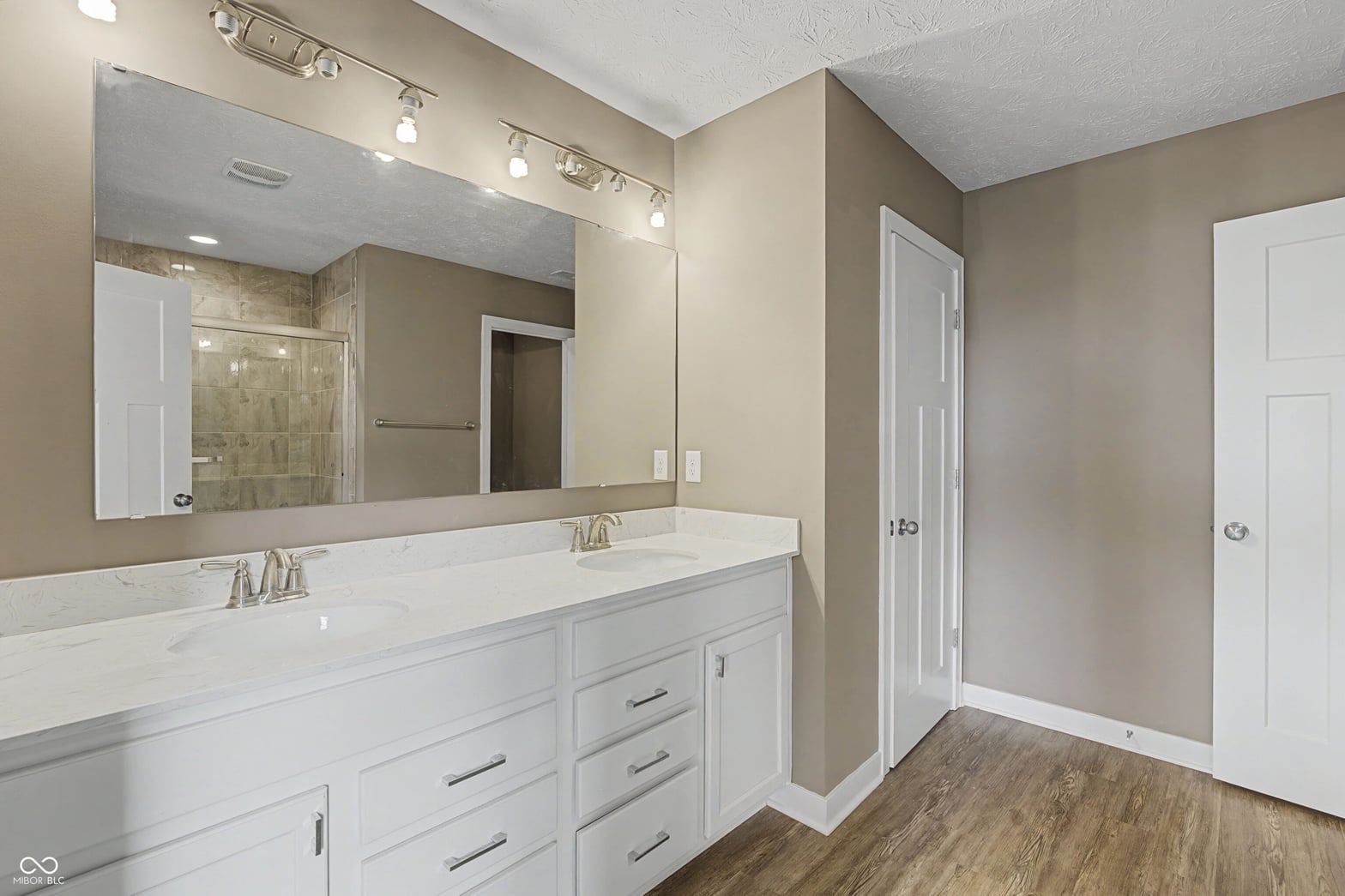 Spacious primary bath with elegant double vanity and updated fixtures.