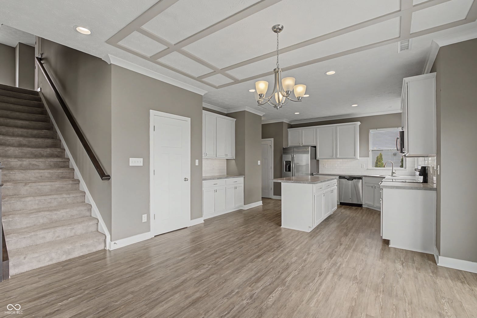 Modern kitchen with island and coffered ceiling design.