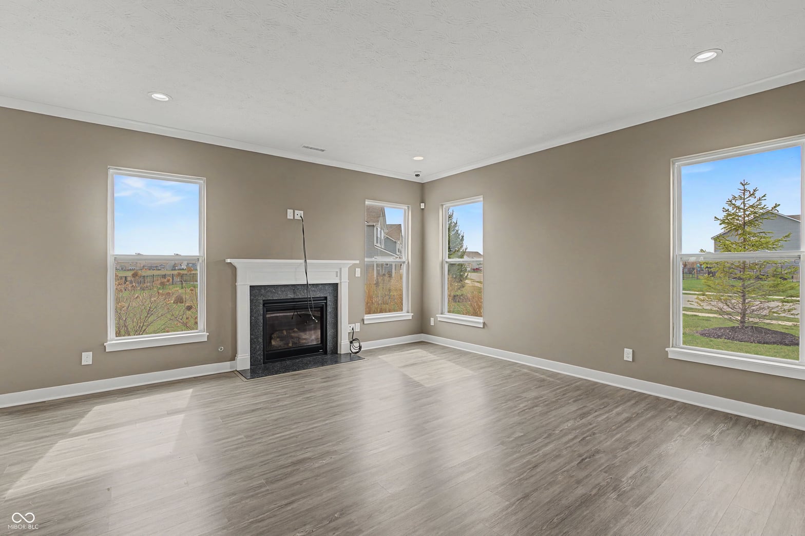 Bright family room with fireplace and expansive windows.