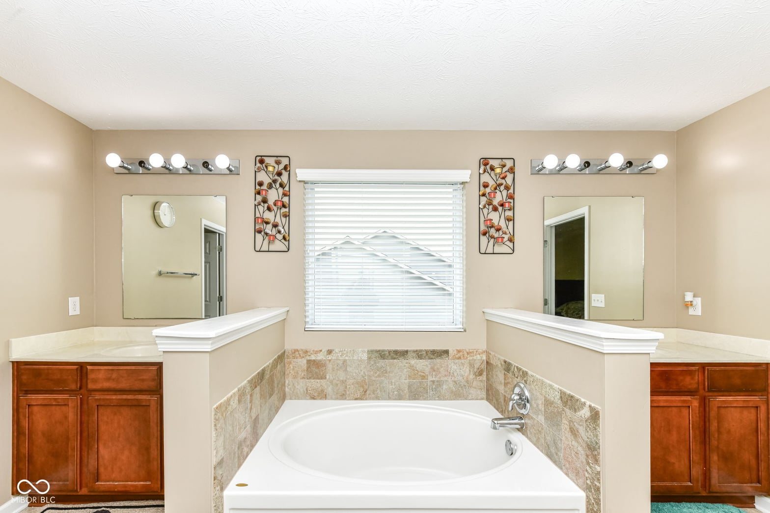 Spacious primary bath with dual vanities and soaking tub.