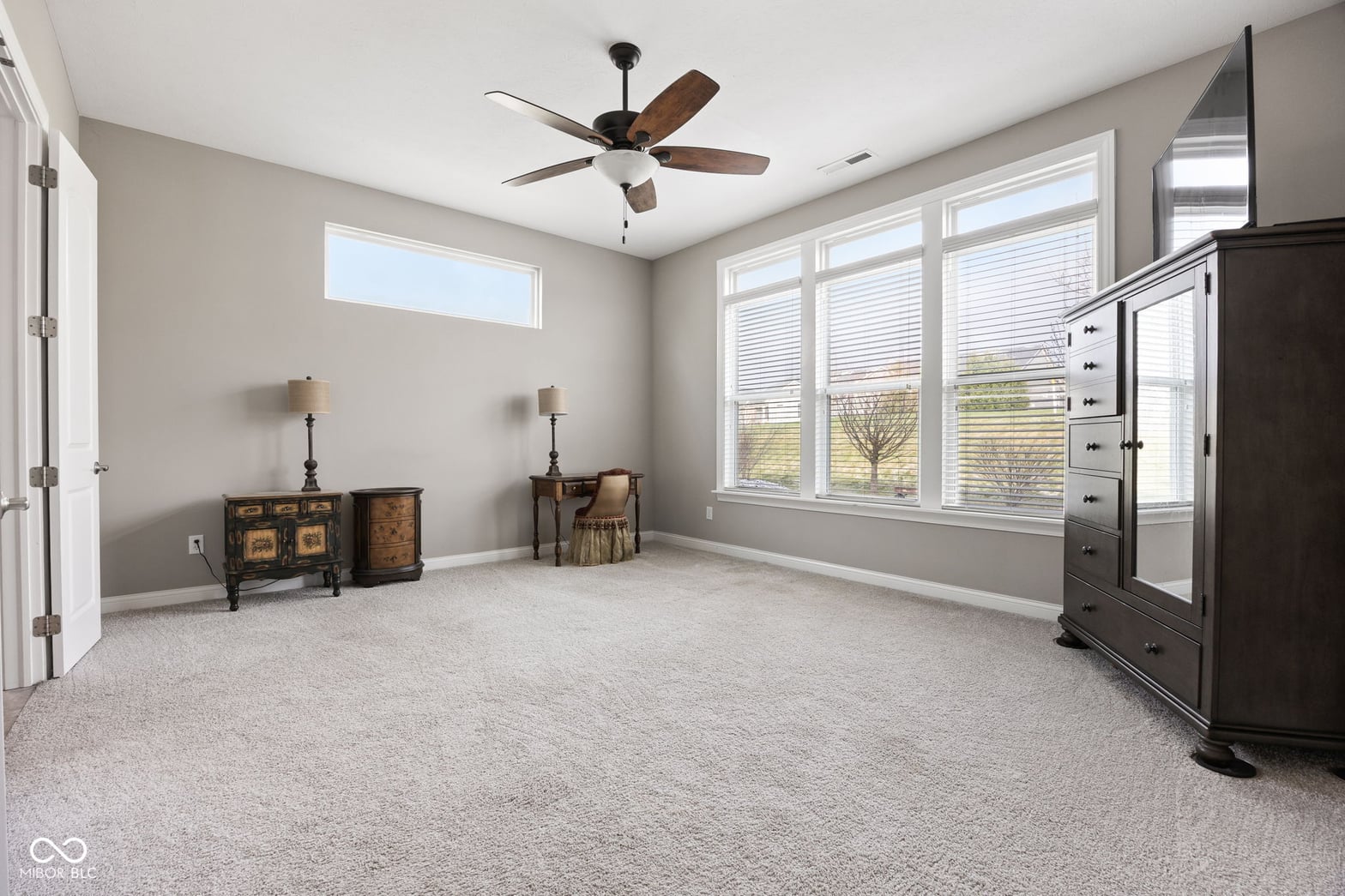 Spacious primary suite with abundant natural light and high ceilings.