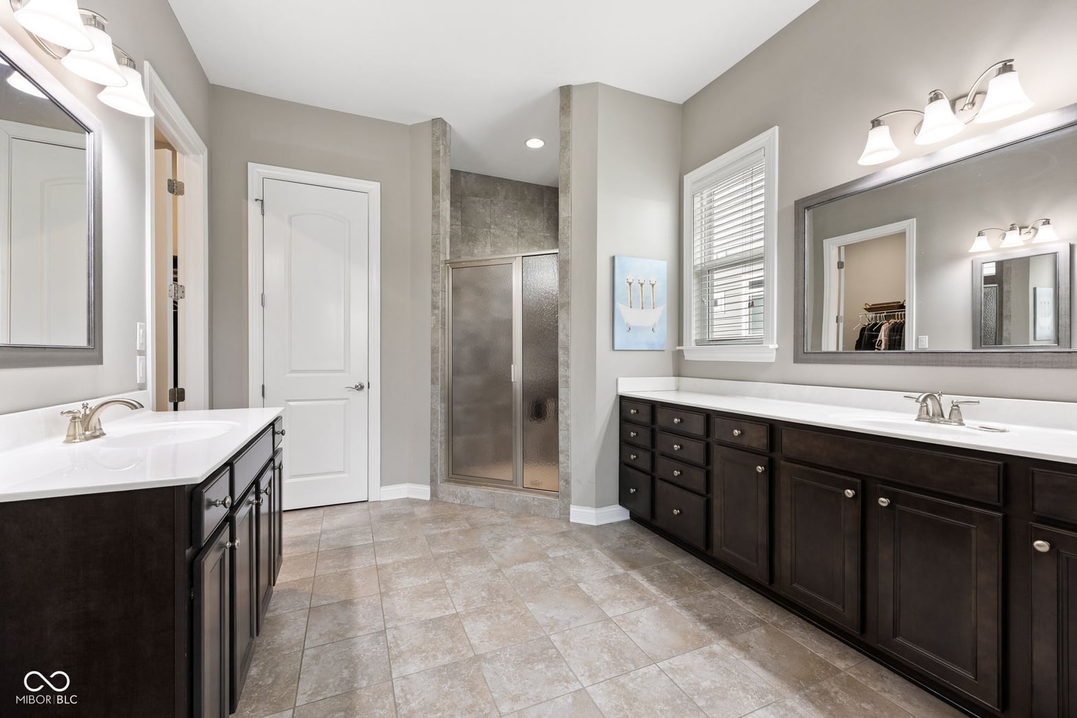 Spacious primary bath with dual vanities and luxury shower.