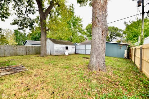 Backyard at 214 Tippecanoe Drive, Noblesville, IN — Spacious backyard with mature trees and storage.