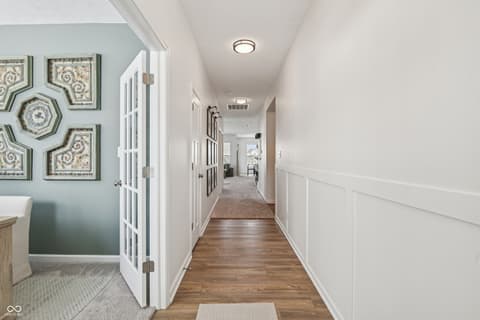 Hallway at 82 Hovden Drive, Cicero, IN — Bright hallway with elegant wainscoting and hardwood floors.