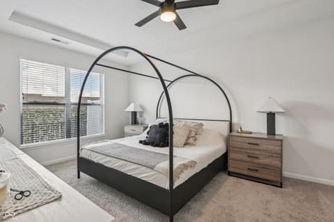 Primary bedroom at 82 Hovden Drive, Cicero, IN — Bright primary bedroom with striking black canopy bed.