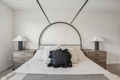 Primary bedroom at 82 Hovden Drive, Cicero, IN — Bright modern bedroom with striking arched metal headboard.