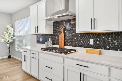 Kitchen at 12338 French Cattle Way, Noblesville, IN — Modern kitchen with striking black hexagonal backsplash.