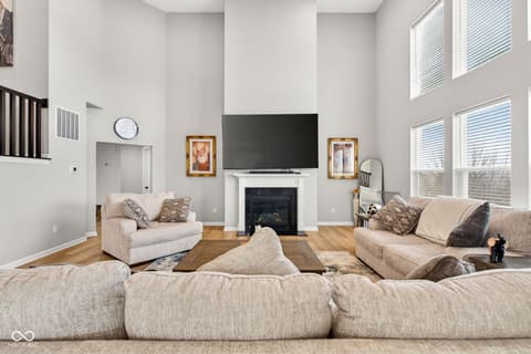 Living room at 12338 French Cattle Way, Noblesville, IN — Spacious living room with fireplace and soaring ceilings.