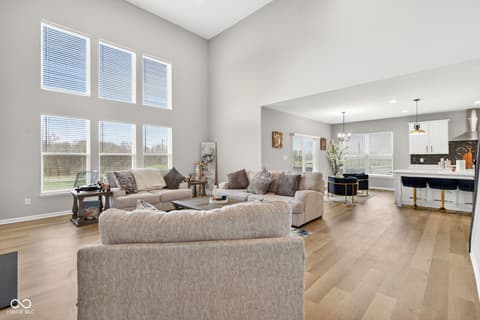 Living room at 12338 French Cattle Way, Noblesville, IN — Bright open-concept living space with vaulted ceilings.