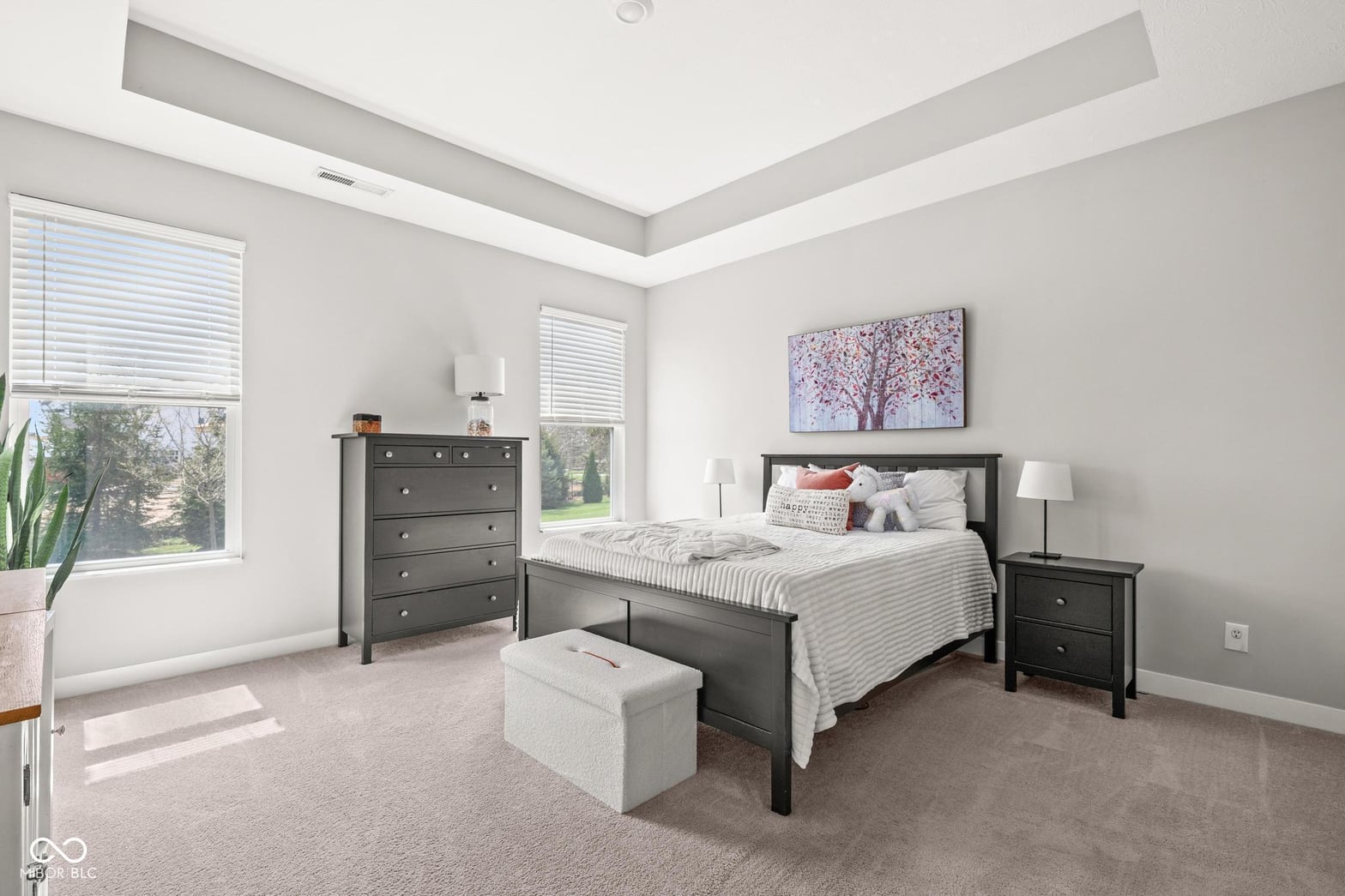 Bright primary bedroom with skylights and coffered ceiling.