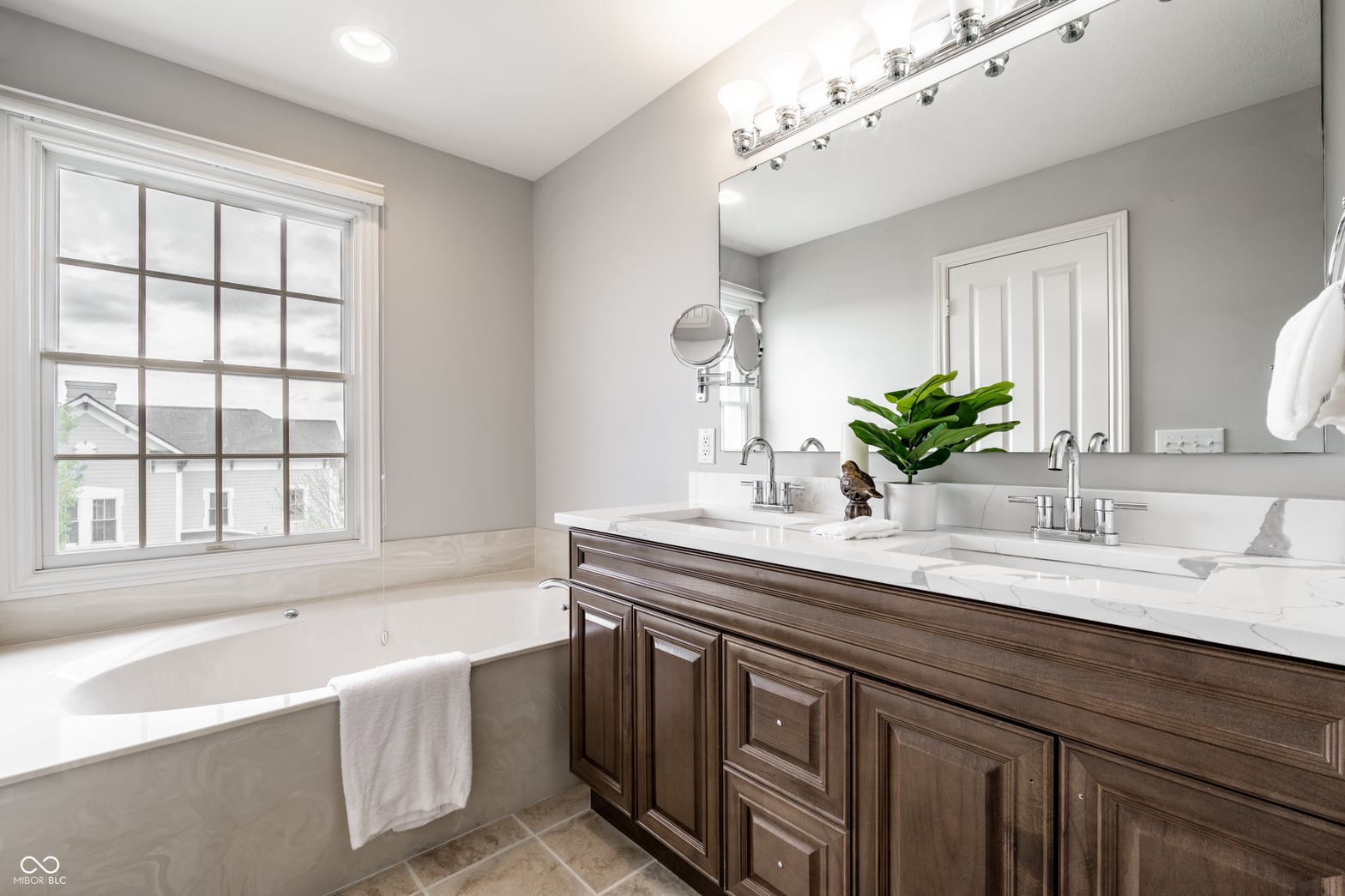 Elegant primary bath with spa-like freestanding tub and marble vanity.